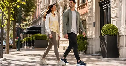 Iemand past verschillende Skechers schoenen in een lichte woonkamer met meerdere dozen ernaast