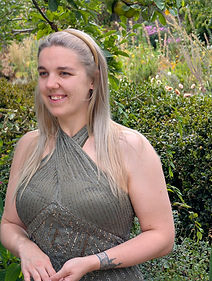 A woman in a sequined 1930s style dress is smiling and looking out of frame