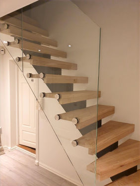 Schody na belce centralnej , drewniane stopnie, szklana balustrada, styl nowoczesny.