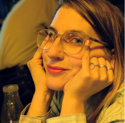 Smiling woman wearing glasses, looking towards viewer