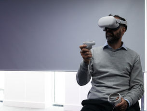 A man using a VR Headset and controllers mid motion