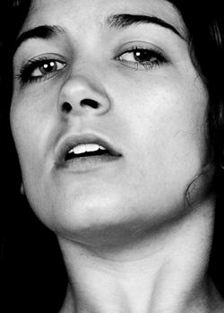 Incrédulité - Photo en noir et blanc d'un visage de femme sur fond noir. La bouche ouverte, la tête