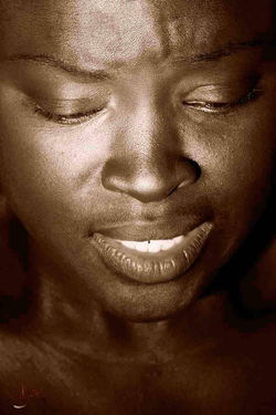Humilité - Photographie en clair-obscur par Dominique Dupray. Visage d'une femme à la peau noire sur