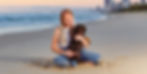 Girl relaxing on the beach with her Dachshund