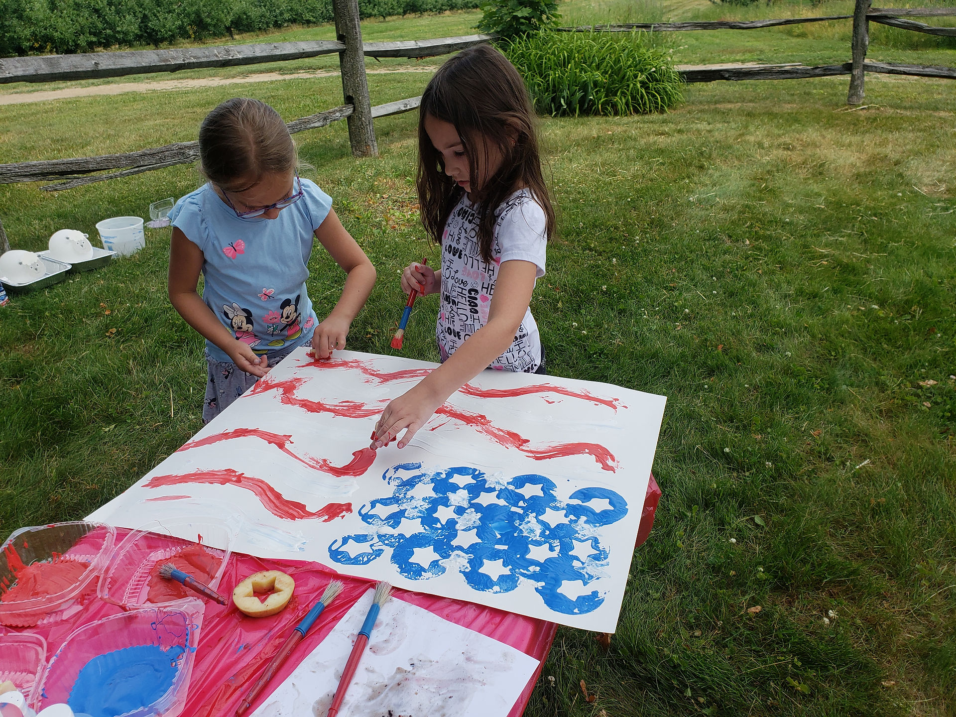 kid cousins work together to create flag from ny apples and paints
