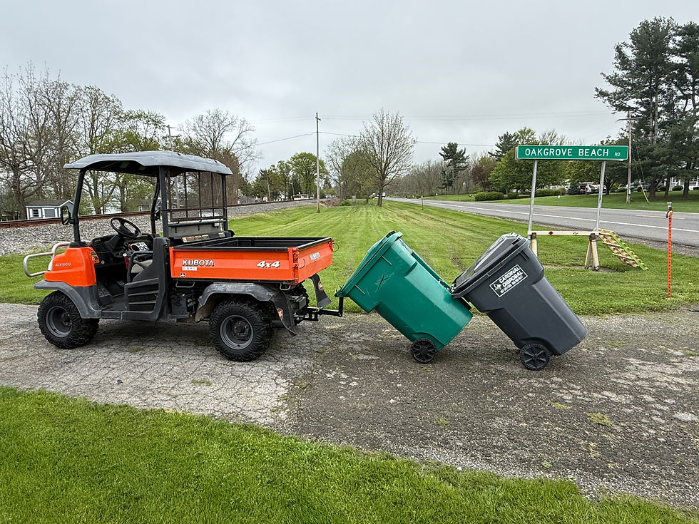 Eye-level view of a UTV equipped with a heavy-duty trash hauling trailer on a gravel driveway