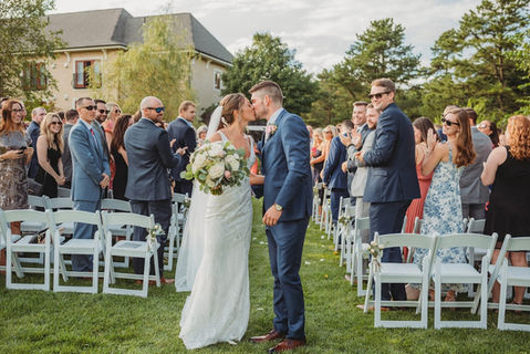 bride and groom kissing at their outdoor wedding ceremony in the Monet Gardens at Mirbeau