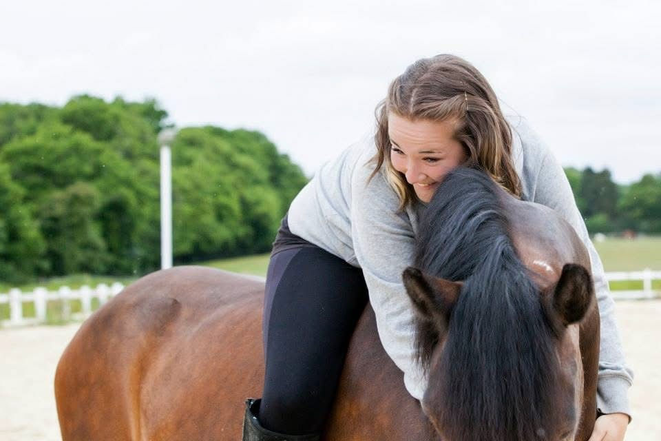 Horse & rider, rider laughing lying over horse's neck