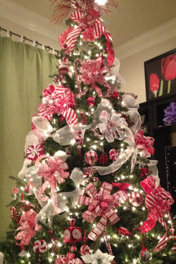 Budget friendly christmas tree in colors red and white with theme sweet candies.