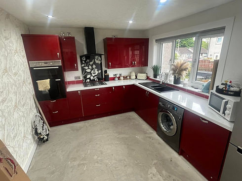Bold kitchen makeover featuring vibrant red gloss vinyl wrapped units and black work surfaces