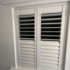 Close-up of elegant white wooden window shutters on a domestic window