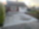 Newly laid grey gravel driveway in front of a residential brick bungalow