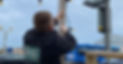 Rear view of an electrician working on high level external wiring outdoors