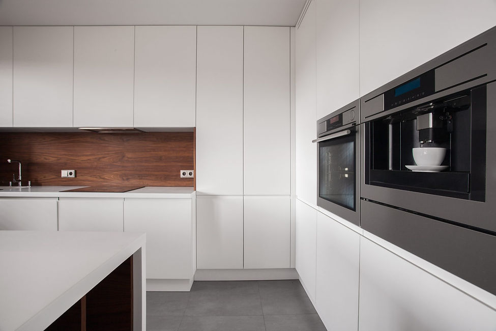 Modern kitchen interior in Kirkcaldy featuring built-in ovens and clean white vinyl wrapped cabinetry