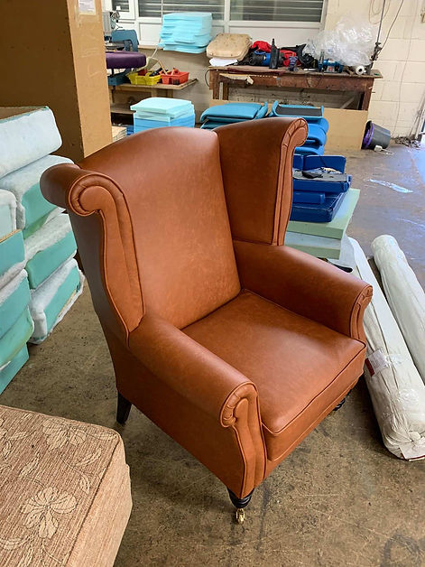 Tan leather wingback armchair restored using traditional methods