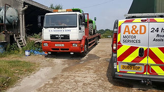Red and white breakdown recovery truck parked outside the A&D Motor Services garage