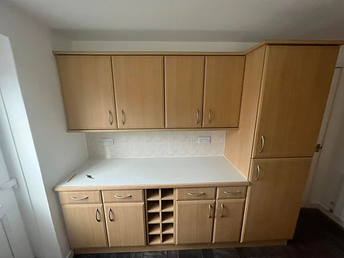 Light oak effect vinyl wrapped kitchen cupboards with a clean white worktop in a Fife home
