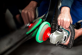 Car body specialist using a rotary polishing machine on paintwork