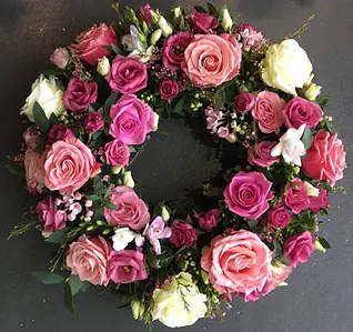 Circular funeral wreath featuring pink roses and greenery