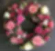 Circular funeral wreath featuring pink roses and greenery
