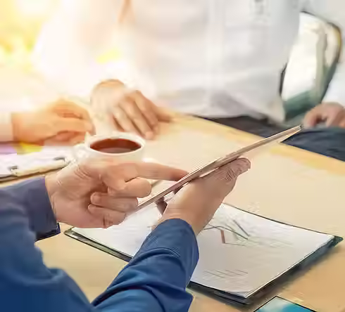 Professionals having a discussion over a digital tablet and coffee
