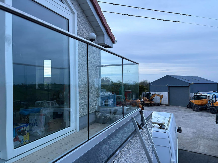 Modern industrial courtyard with glass railing reflecting the sky