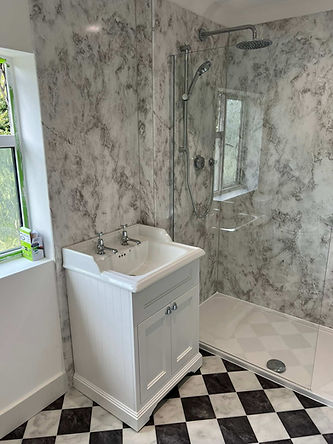Walk in shower with marble effect wall panels and traditional vanity unit