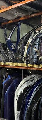 Organised rows of colourful second hand car doors