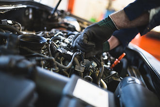 Local mechanic working on a vehicle engine bay in a workshop