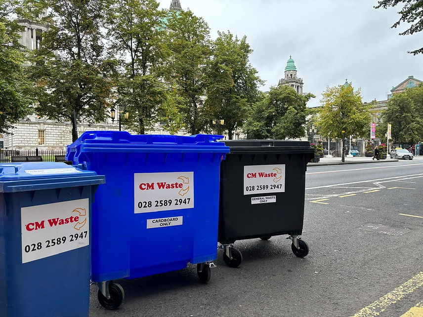 Three trash cans labeled "CM Waste" arranged in a row, indicating designated waste disposal areas