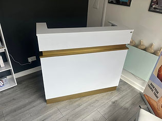 Reception desk at a business premises finished with a sleek white and gold vinyl wrap