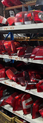 Shelves stacked high with red car parts in a breaker yard
