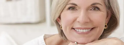Close up of a smiling senior woman with Enigma cosmetic dentures