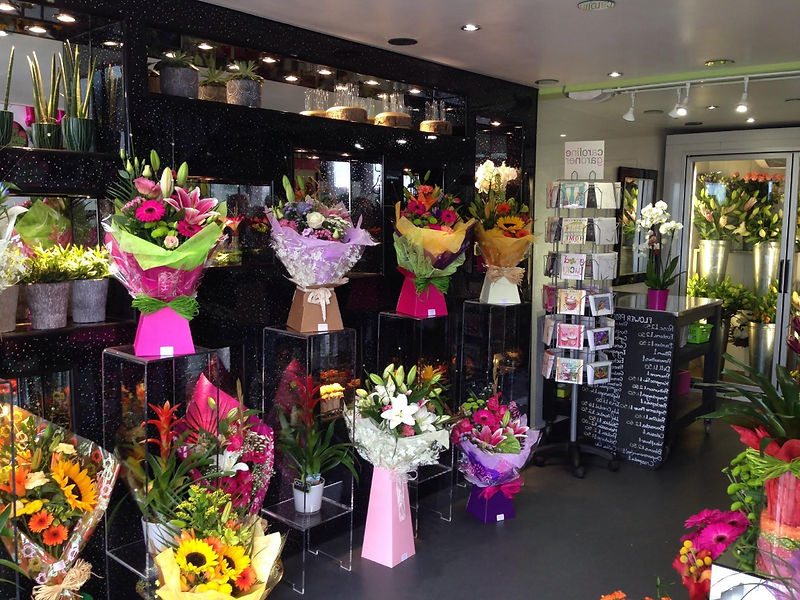 Florist shop interior with vibrant pink and green mixed flower bouquets on display