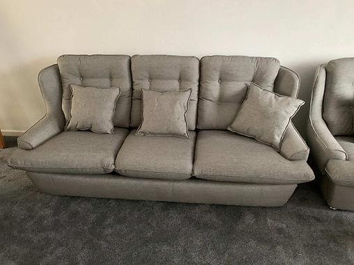 Light grey tufted sofa with plush accent cushions