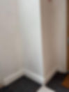Close up of damp staining and peeling paint on a white skirting board