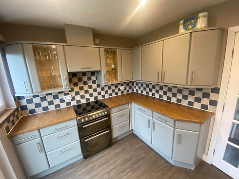 Refreshed kitchen featuring grey vinyl wrapped cabinets and a classic chequered tile splashback
