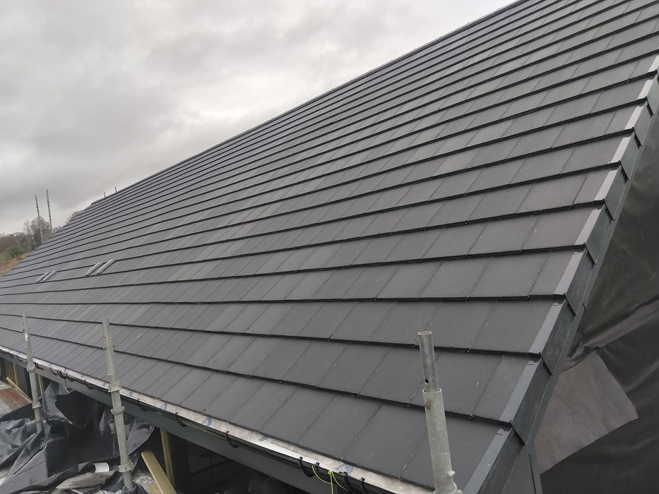 Close-up of newly installed dark grey interlocking roof tiles