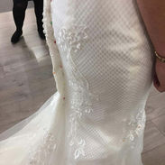 Detailed view of a white satin wedding gown skirt and structured bodice