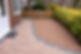 Curved block paving path next to a brown gravel resin stone driveway section