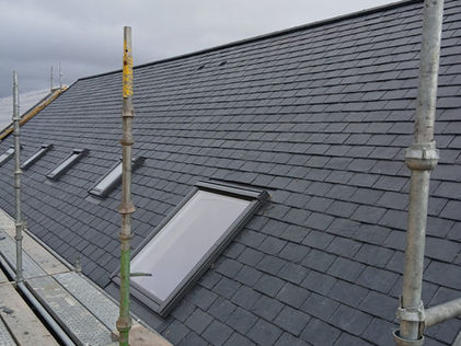 Completed grey slate roof with professionally installed lead valleys and flashing details