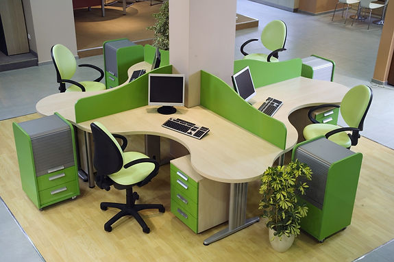 Office environment showing multiple workstations with green and white vinyl wrapped desk dividers