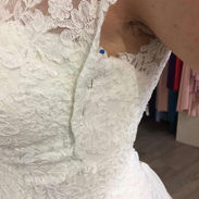 Side profile of a lace bridal bodice showing intricate floral embroidery and beadwork