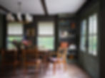 Moody dining room with built-in open shelves, rectangular wood dining chair and curved back dining chairs