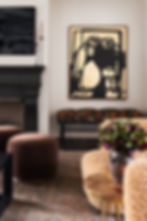 Eclectic living room with modern art, boucle lounge chair and black fireplace