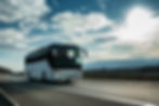 White Modern comfortable tourist bus driving through highway at bright sunny sunset. Trave
