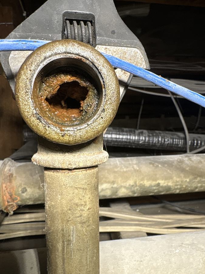 Old galvanised water pipe rusted almost shut on the inside