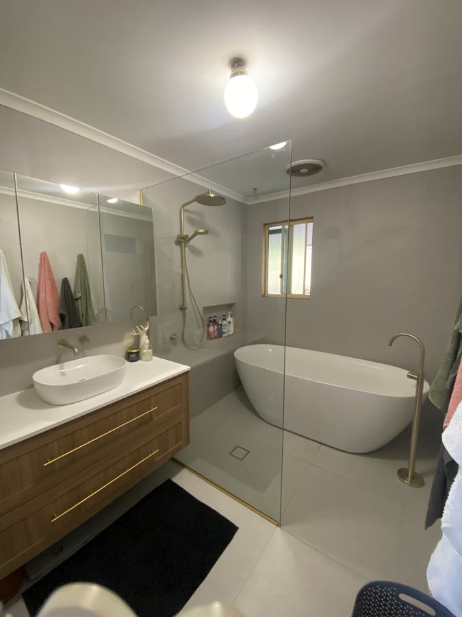 Bathroom renovation with freestanding bath and brushed brass rail shower