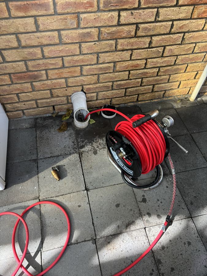 High-pressure drain jetter clearing a blocked drain