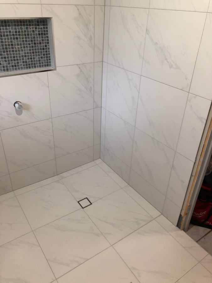 Tiled shower with recessed niche and square floor waste